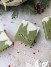 Load image into Gallery viewer, BEAM natural body care evergreen soap.  Three Christmas soaps on a wooden board.  Green and white natural soap.
